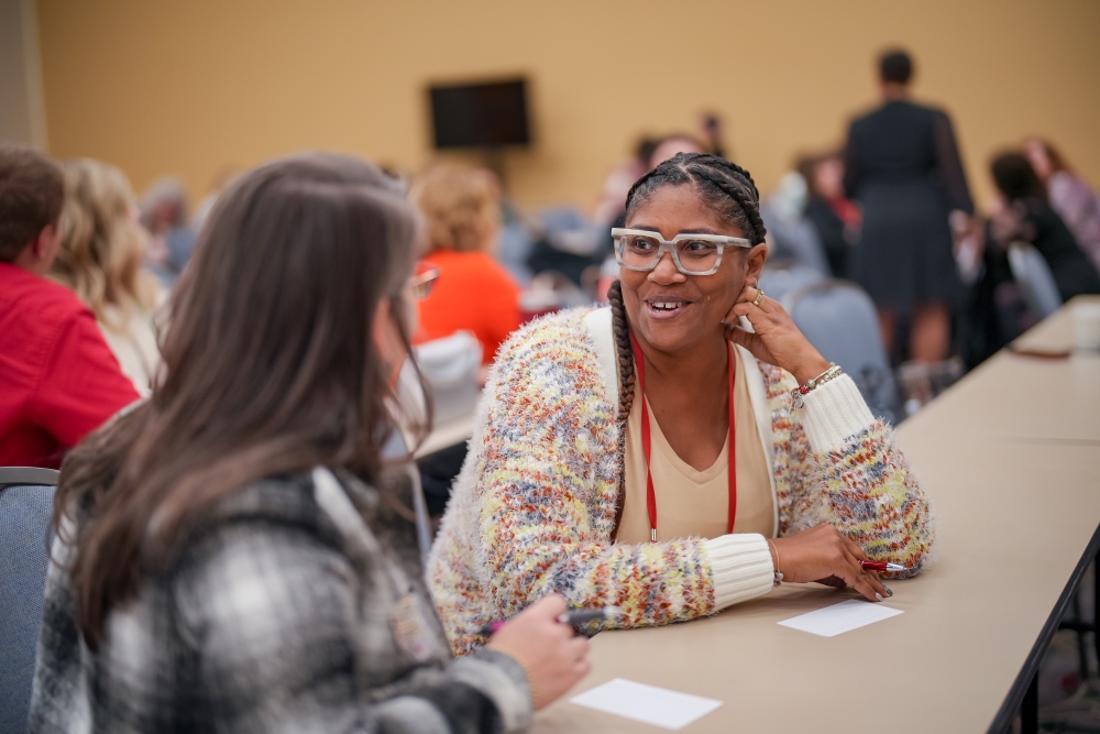 An image showing two women in conversation during the Women In Buses council meeting at ABA Marketplace 2025.